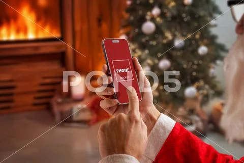 Santa touching smartphone screen in decorated cabin PSD Template