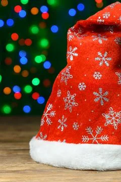 Santa's hat on rustic wooden table against blurred background with bokeh Stock Photos