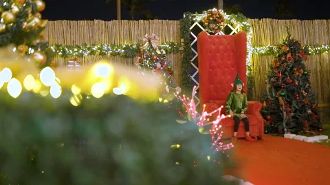 Santa's helper or elf sits on Santa's chair, celebrates Christmas. Child Stock Footage 117281932