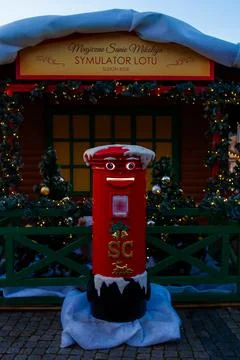 Santas mailbox stands in front of a festive wooden structure in winter Stock Photos
