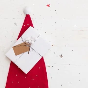 Santa's red hat and nice Christmas gifts box wrapped in white paper and decor Stock Photos