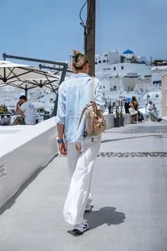 Santorini, Greece - 05. 24. 2025. Woman tourist walking a narrow alley Stock Photos