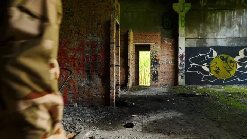 Sapper with mine detector goes in abandoned building Stock Footage 94358580