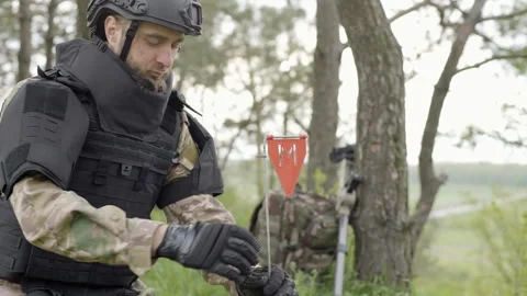 The sapper puts a red mark next to dicovered mine Video stock 240502500