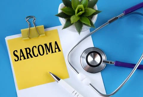 SARCOMA - word on a yellow notebook on a blue background with a stethoscope.. Stock Photos
