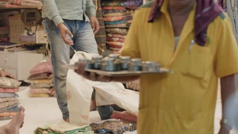 Sari vendor shows customer different fabrics and dresses Stock Footage 90966306