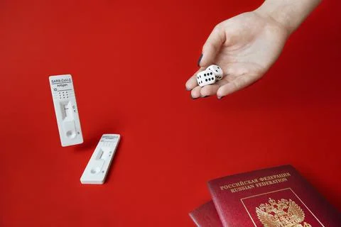 SARS-Cov-2 Antigen Test,hand with dice on red,pair tourist passport.Luck concept Stock Photos
