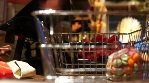 Сashier in a candy shop taking purchases from a busket and putting them into a Video stock 65530615