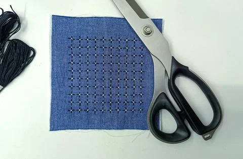 Sashiko embroidery sample with scissors on workspace Stock Photos
