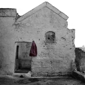 Sassi of Matera: red jacket hanging outside the door 库存照片