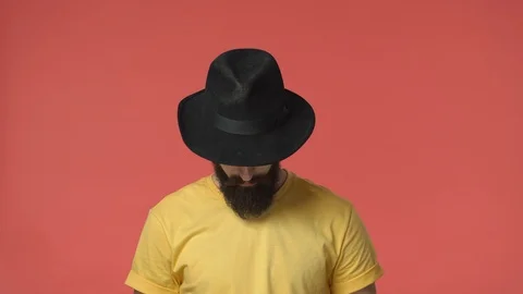 Sassy good-looking middle-eastern bearded man in black hat, look down, raise Stock Footage 115779794