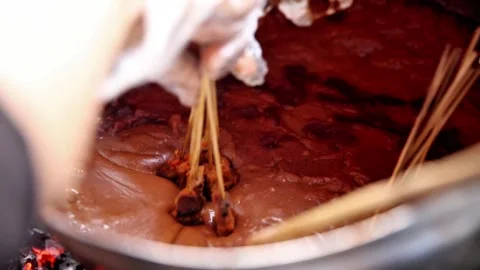 Satay Padang dipped in a typical Sate Padang sauce Stock Footage 272298447
