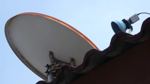 Satellite Dish Mounted on Rooftop Against Clear Blue Sky, Residential Vídeo Stock 339035871