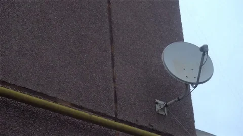 Satellite receiver dish on the wall with a cloudy sky and cloud behind Video stock 82732773