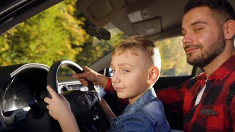 Satisfied 35-aged bearded father and cute smiling boy sitting at the helm and Stock Footage 121661389