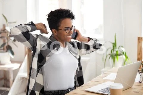 Satisfied African woman talk by phone, happy finish to work Stock Photos