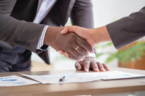 Satisfied black client shaking hands, thanking the manager for good financi.. Stock Photos