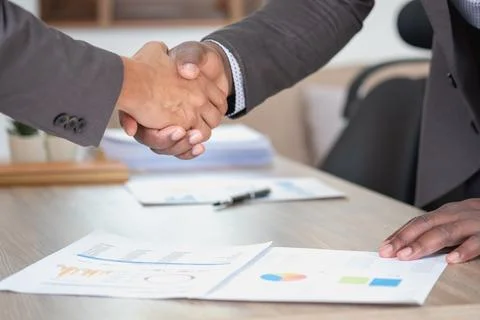 Satisfied black client shaking hands, thanking the manager for good financi.. Stock Photos