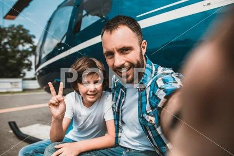 Satisfied boy taking photo with beaming dad Stock Photos