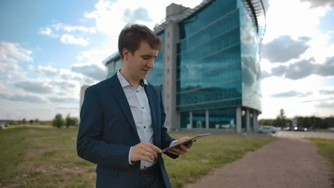 Satisfied businessman working on tablet PC. Smiling and approval with direct Stock Footage 119511795