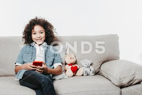 Satisfied child using cellphone with comfort Stock Photos