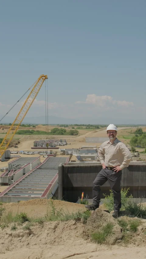 Satisfied civil engineer in hard hat nodding at camera with hands on hips a.. Stock Footage 338008930