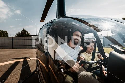 Satisfied dad and boy inside of rotorcraft Stock Photos