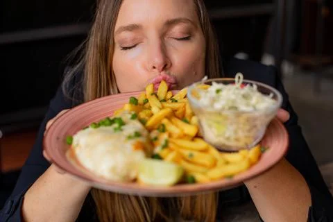 Satisfied, delightful woman with close eyes joy, smell tasty plate of food in Stock Photos