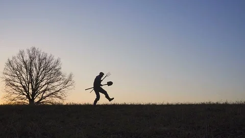 A satisfied farmer dances ib the field. Silhouette of a sunset or sunrise in 스톡 동영상 88281559