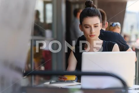 Satisfied female freelancer sitting in front of a laptop Stock Photos