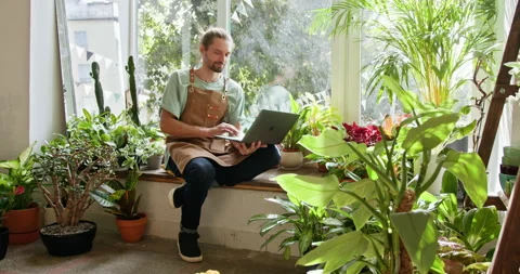 Satisfied handsome millennial man admiring and checking the condition of plants Stock Footage 274130287
