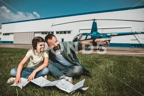 Satisfied kid and father resting on filed Stock Photos