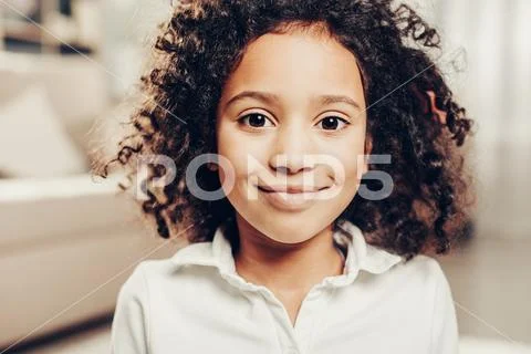 Satisfied kid with wavy locks staring with joy Stock Photos