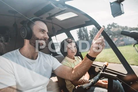 Satisfied male speaking with kid in vehicle Stock Photos