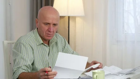 Satisfied Man Calculating Payments and Incomes Using Adding Machine Stock Footage 76901817