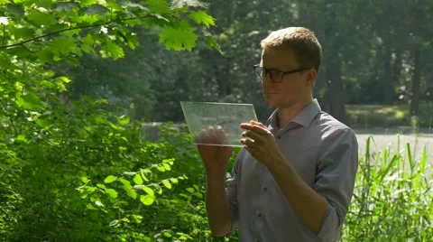 Satisfied Man Clicks Virtual Tablet in Park Smiling Man is Chatting Doing Stock Footage 63807500