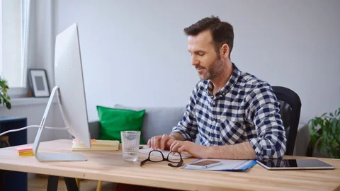 Satisfied man working on computer from home office Stock Footage 126829532