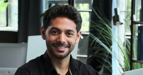 Satisfied Middle Eastern office worker Smiles into the Camera Stockbeeldmateriaal 254436778