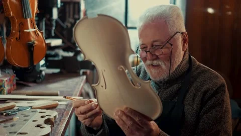 Satisfied pensioner is engaged in making violins in his free time Stock Footage 167112882