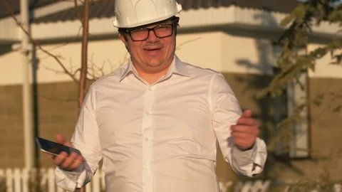Satisfied smiling architect engineer in protective helmet and white shirt Stock Footage 269458272