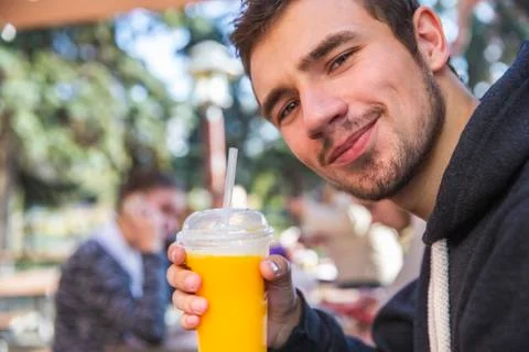 Satisfied young man is looking at the camera with a smile on his face. He is  Stock Photos