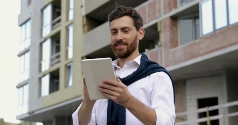 Satisfied young man looking at digital tablet and making winner gesture with Stock Footage 140681116