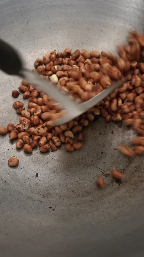 Satisfying dry cooking process of brown peanut roast snack using metal spat.. Stock Footage 341273138
