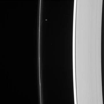 Saturn s moon Prometheus orbits near some of its handiwork in the F ring i... Stock Photos