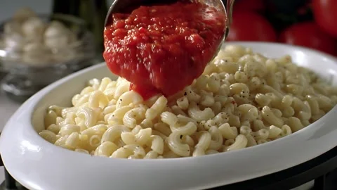 The sauce is poured over the pasta on the serving plate in slow motion. Stock Footage 140671967