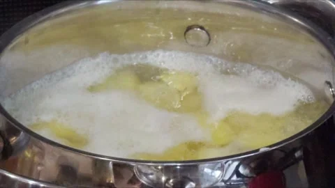 A saucepan of boiling water with bubbles and steam. Cooking potatoes. Steam.. Stock Footage 288705193