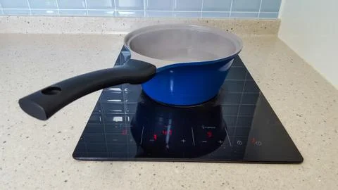Saucepan on induction cooker in kitchen Фото