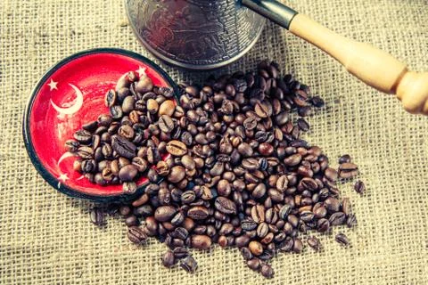 Saucer with elements of Turkish flag, coffee beans and copper coffee pot Stock Photos
