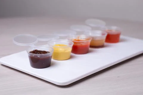 Saucers with different types of sauce on a white background Stock Photos