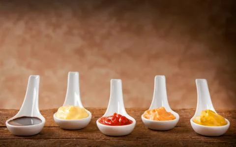 Sauces mixed in the ceramic spoons Foto stock